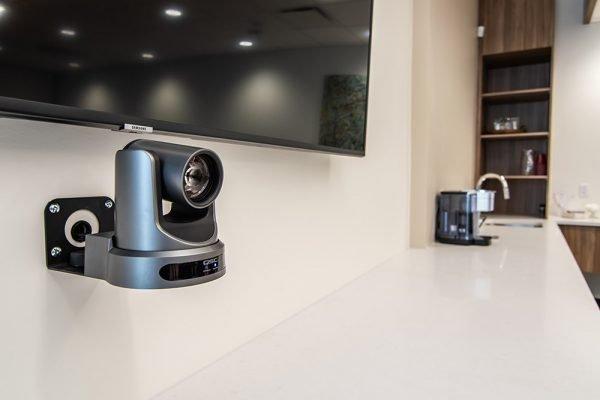 a video camera mounted on a wall next to a television